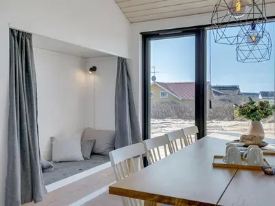 a dining room with a table and chairs and a large window at Holiday Home Aiko - 50m from the sea by Interhome in Torsted