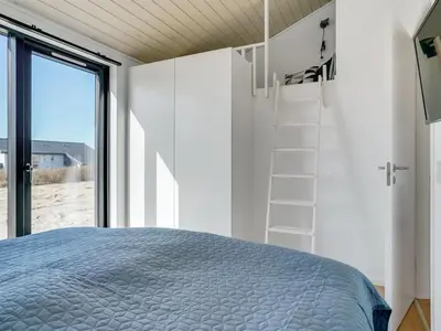 a bedroom with a bed and a large window at Holiday Home Aiko - 50m from the sea by Interhome in Torsted
