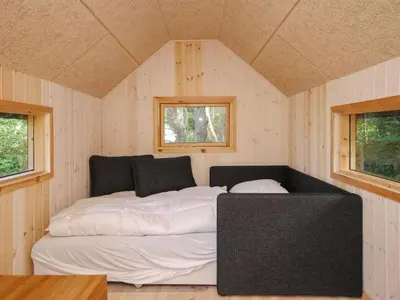 a bed in a small room with two windows at Holiday Home Konrad - 400m from the sea by Interhome in Torsted