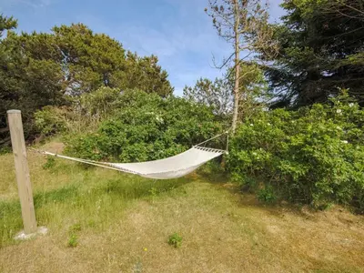 a hammock hanging from a pole in a field at Holiday Home Konrad - 400m from the sea by Interhome in Torsted