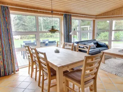 a dining room with a table and chairs and a couch at Holiday Home Konrad - 400m from the sea by Interhome in Torsted