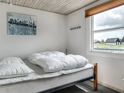 a bed with white sheets in a room with a window at Holiday Home Fabiana - 350m from the sea by Interhome in Torsted