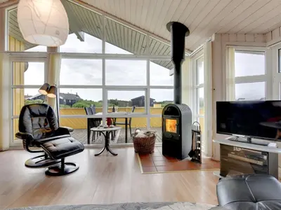 a living room with a chair and a fireplace at Holiday Home Ritte - 200m from the sea by Interhome in Torsted