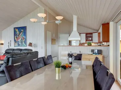 a dining room and living room with a table and chairs at Holiday Home Ritte - 200m from the sea by Interhome in Torsted