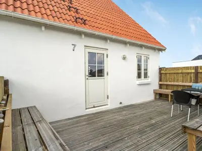a white house with an orange roof and a wooden deck at Holiday Home Bernice - 150m from the sea by Interhome in Torsted