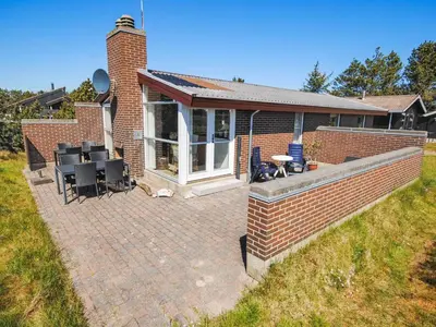 a brick house with a patio with a table and chairs at Holiday Home Jerrik - 900m from the sea by Interhome in Torsted