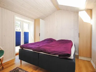 a bedroom with a bed with a purple blanket on it at Holiday Home Jerrik - 900m from the sea by Interhome in Torsted