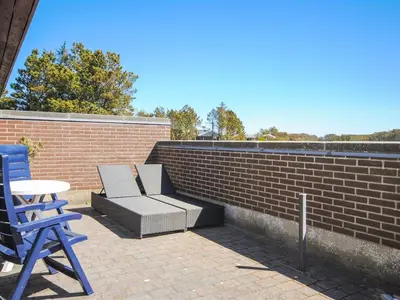 a patio with two chairs and a table and a brick wall at Holiday Home Jerrik - 900m from the sea by Interhome in Torsted