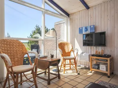a screened in porch with chairs and a television at Holiday Home Jerrik - 900m from the sea by Interhome in Torsted