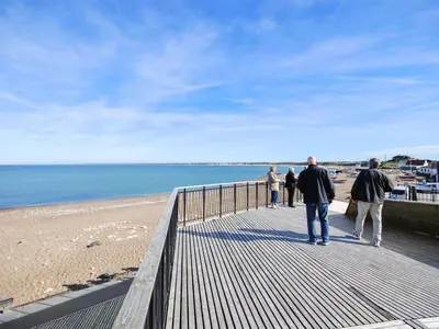 a group of people walking on a boardwalk at the beach at Holiday Home Adisl - 350m from the sea by Interhome in Torsted