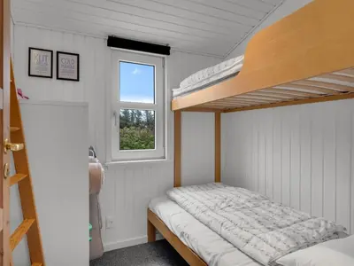 a bedroom with a bunk bed and a window at Holiday Home Adisl - 350m from the sea by Interhome in Torsted