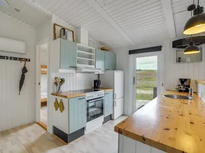 a kitchen with blue cabinets and a wooden counter top at Holiday Home Mads - 950m from the sea by Interhome in Torsted