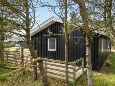 a black building with a fence in front of it at Holiday Home Mads - 950m from the sea by Interhome in Torsted