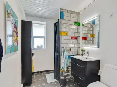 a bathroom with a stone wall with a sink and a toilet at Holiday Home Örjan - 400m from the sea by Interhome in Torsted