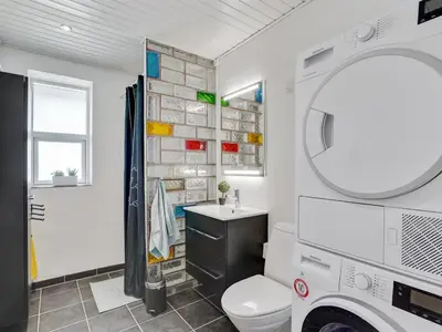 a bathroom with a toilet and a sink and a mirror at Holiday Home Örjan - 400m from the sea by Interhome in Torsted