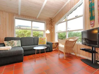 a living room with a couch and a tv at Holiday Home Dode - 225m from the sea by Interhome in Torsted