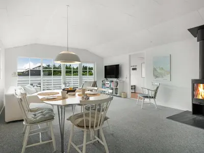 a kitchen and living room with a table and chairs at Holiday Home Kanerva - 350m from the sea by Interhome in Torsted
