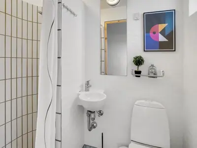 a white bathroom with a toilet and a sink at Holiday Home Teijo - 400m from the sea by Interhome in Torsted