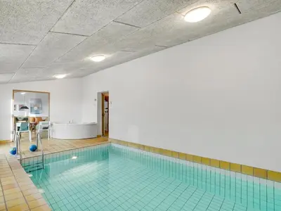 a large swimming pool with a blue tile floor at Holiday Home Teijo - 400m from the sea by Interhome in Torsted