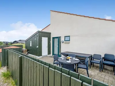 a patio with tables and chairs and a fence at Holiday Home Teijo - 400m from the sea by Interhome in Torsted