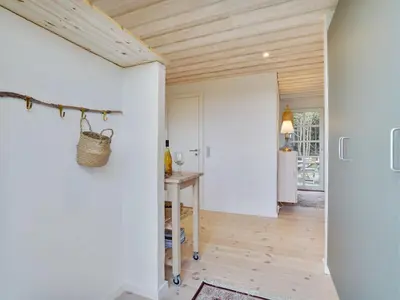 a kitchen with white walls and a wooden ceiling at Holiday Home Meindor - 350m from the sea by Interhome in Torsted