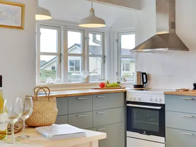 a kitchen with gray cabinets and windows and a counter at Holiday Home Meindor - 350m from the sea by Interhome in Torsted