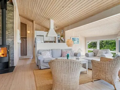 a living room with a couch and a table and chairs at Holiday Home Abel - 350m from the sea by Interhome in Løkken