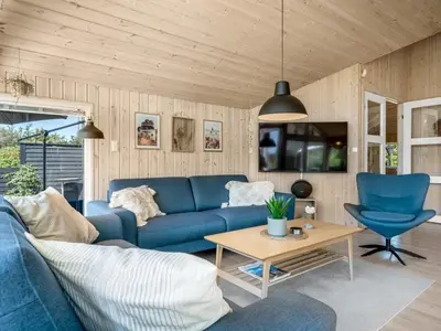 a living room with a blue couch and a table at Holiday Home Federica - 500m from the sea by Interhome in Løkken