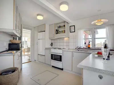 a kitchen with white cabinets and a counter top at Holiday Home Tabea - 150m from the sea by Interhome in Løkken