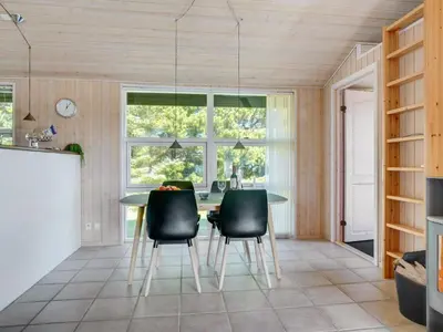 a dining room with a table and black chairs at Holiday Home Elsabet - 750m from the sea by Interhome in Løkken