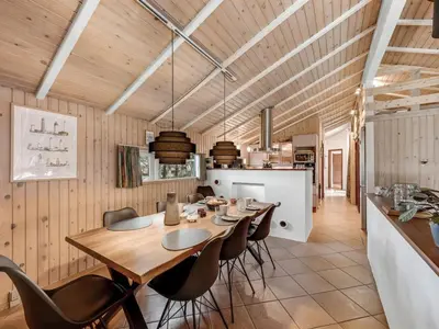 a dining room and kitchen with a table and chairs at Holiday Home Sunneva - 1km from the sea by Interhome in Løkken