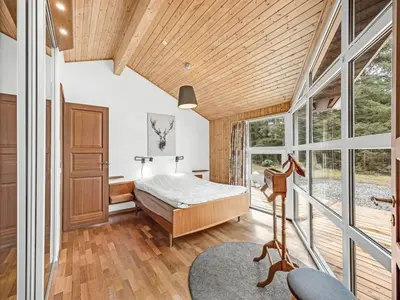 a bedroom with a bed and a large window at Holiday Home Sunneva - 1km from the sea by Interhome in Løkken