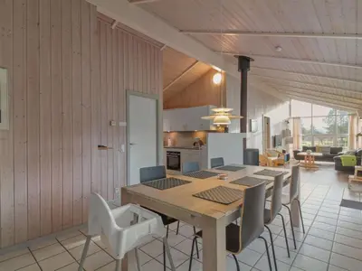a kitchen and dining room with a table and chairs at Holiday Home Panu - 600m from the sea by Interhome in Løkken