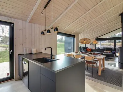 a kitchen with a counter top and a living room at Holiday Home Vanamo - 300m from the sea by Interhome in Løkken