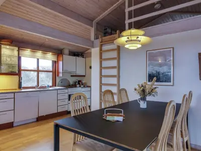 a kitchen and dining room with a table and chairs at Holiday Home Essie - 250m from the sea by Interhome in Løkken
