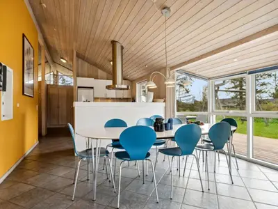 a kitchen and dining room with a table and chairs at Holiday Home Aleta - 500m from the sea by Interhome in Løkken