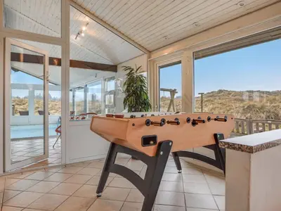 a game room with a pool table on a balcony at Holiday Home Falka - 800m from the sea by Interhome in Løkken