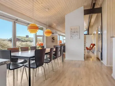 a dining room with a table and chairs at Holiday Home Falka - 800m from the sea by Interhome in Løkken