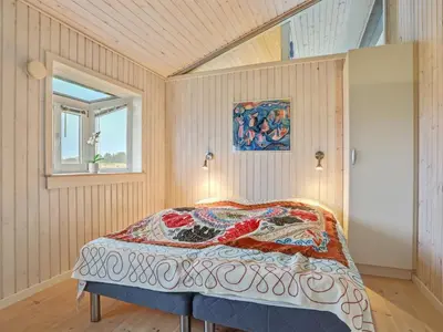 a bedroom with a bed and a window at Holiday Home Falka - 800m from the sea by Interhome in Løkken