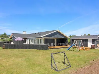 a house with a yard with a playground at Holiday Home Dome - 750m from the sea by Interhome in Løkken