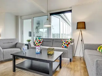 a living room with a couch and a table at Holiday Home Dome - 750m from the sea by Interhome in Løkken