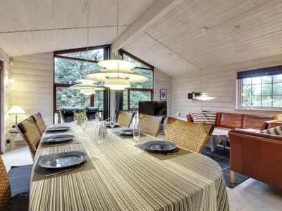 a dining room with a long table with chairs at Holiday Home Jo - 1-2km from the sea by Interhome in Løkken
