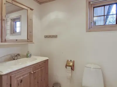 a bathroom with a sink and a mirror and a toilet at Holiday Home Jo - 1-2km from the sea by Interhome in Løkken