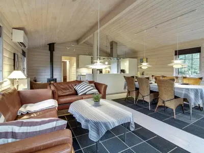 a living room with leather furniture and a dining room at Holiday Home Jo - 1-2km from the sea by Interhome in Løkken