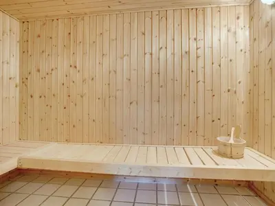 a wooden sauna with a bench in the middle at Holiday Home Lenni - 700m from the sea by Interhome in Løkken