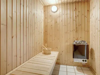 a sauna with a table and a tv in a room at Holiday Home Lenni - 700m from the sea by Interhome in Løkken