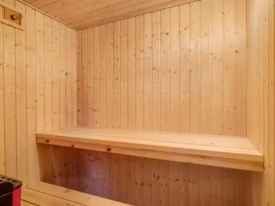 a sauna with a wooden shelf on the wall at Holiday Home Katla - 400m from the sea by Interhome in Løkken