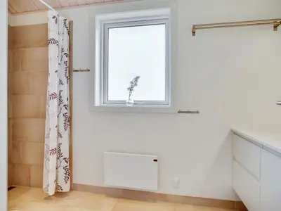 a white room with a window and a radiator at Holiday Home Marthine - 200m from the sea by Interhome in Løkken
