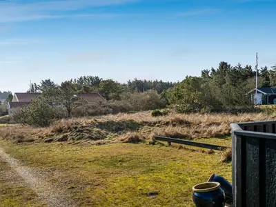 a field of grass with a fence and a house at Holiday Home Ofrath - 350m from the sea by Interhome in Løkken