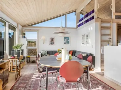 a dining room and living room with a table and chairs at Holiday Home Ofrath - 350m from the sea by Interhome in Løkken